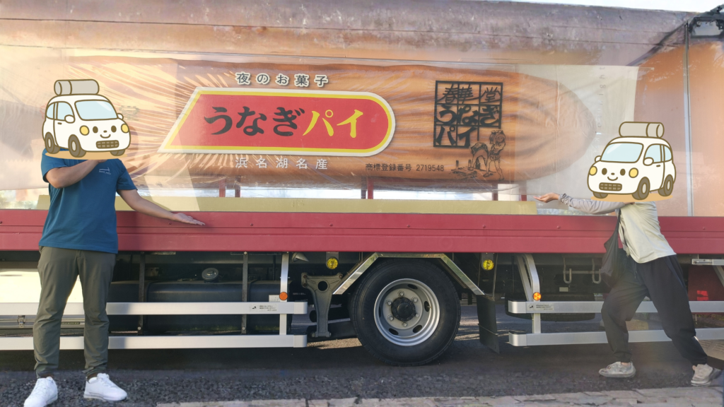 うなぎパイファクトリーで巨大うなぎパイの展示前にポーズをとるブログ主